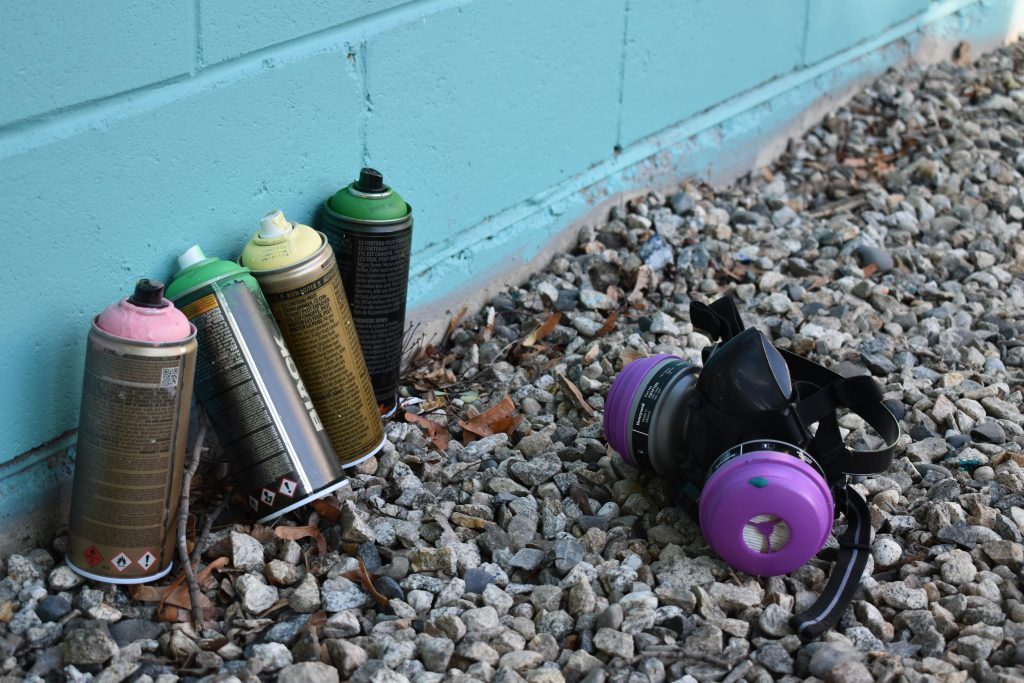 Spray cans and purple respirator
